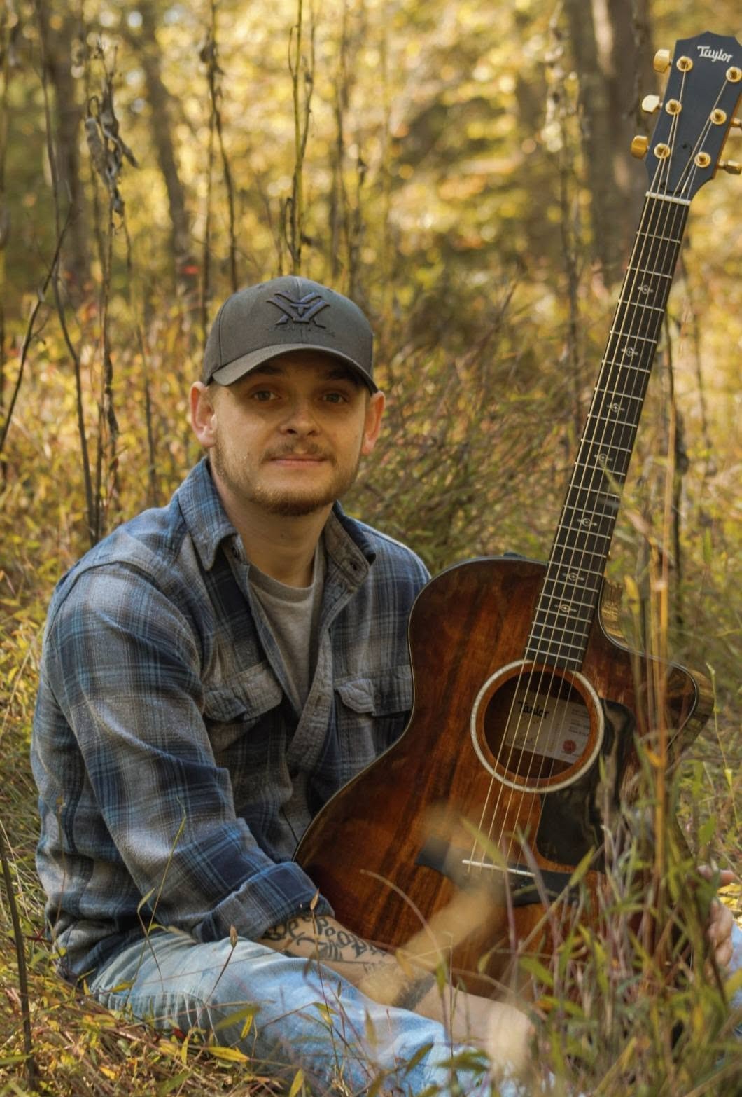 Robbie seated outdoors with his guitar